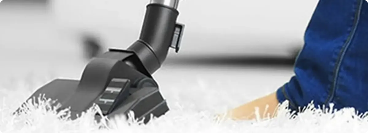 Close-up of a professional vacuuming a white carpet in Winnebago.